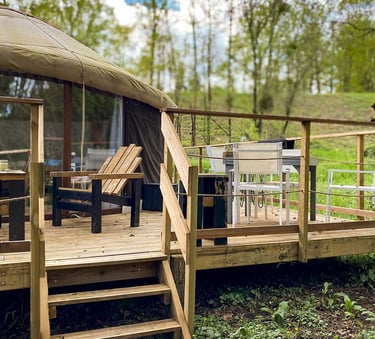 extérieur d'une yourte avec terrasse bois et espaces avec tables et chaises