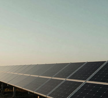 A wide-angle, professional photograph of a solar park at dusk. The sky is a soft sage green and grey, reflecting off the clean, modern solar panels. The composition is clean and minimalist, emphasizing precision and scale.