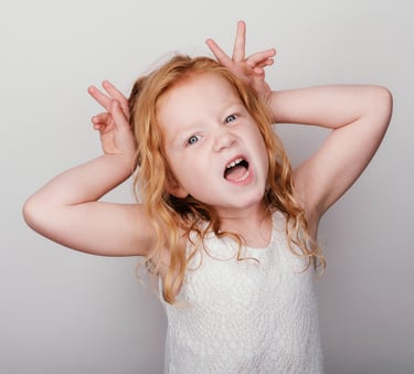 a young girl with blonde hair and a white top