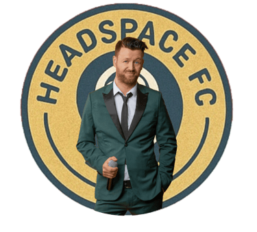 A man in a green tuxedo holding a microphone in front of the Headspace FC circular logo.