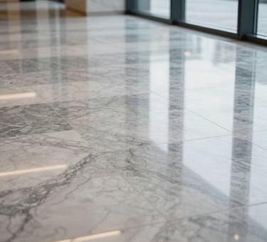 A professional close-up photograph of a polished marble floor in a corporate lobby in Rouen, France / Norman. The reflection of large windows and modern architectural lines is visible on the spotless surface, highlighting excellence and cleanliness.