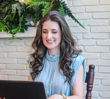 Foto da nutricionista em Jaraguá do Sul, Kamila Kuester, sorrindo enquanto olha para o notebook