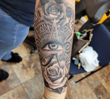 Tatuaje realista rosa y calendario azteca con ojo al centro, Detroit Aztec Tattoo Leon Guanajuato, resena cliente 