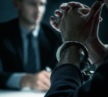man in handcuffs talking to lawyer
