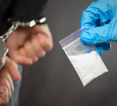 person in handcuffs and drugs in bag being confiscated