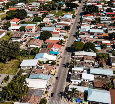 An aerial view of a vibrant South American / Colombian coastal town in Atlántico. Focus on clean streets and community infrastructure. Sunlight, professional high-angle shot with Muted Teal accents.