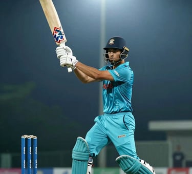 A dramatic low-angle shot of a cricket batsman mid-swing under bright stadium floodlights at night, with a misty dark blue atmosphere and sharp teal accents on the equipment.