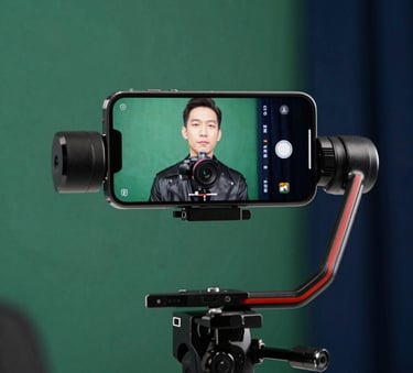 A close-up of a high-end smartphone on a gimbal being used to film an authentic testimonial video in a professional studio with soft emerald green lighting and deep navy blue accents.