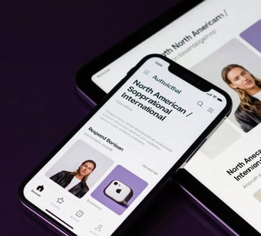 A close-up of a high-end smartphone and tablet displaying a matching responsive e-commerce application, North American / International, set against a dark glass surface with deep violet reflections.