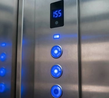 A close-up photograph of a modern, sleek elevator control panel with glowing blue lights, inside a contemporary commercial building in a Mozambican city, professional and high-tech atmosphere, incorporating Royal Blue accents.