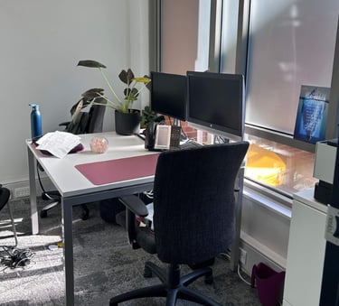a desk with a computer monitor and a desk with a chair