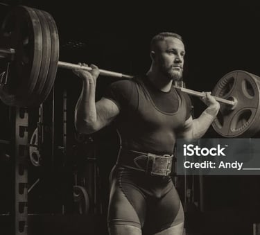 a man holding a barbell in a gym
