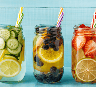 three jars of fruit and water with strawberries and lemonade