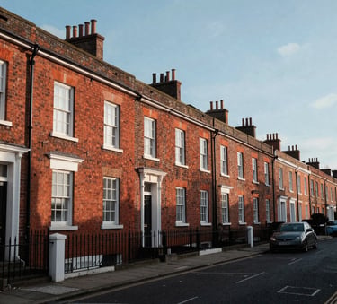 A wide-angle photography shot of a classic British residential street in Bristol with red brick houses, clean composition, soft morning light, and a clear blue sky.