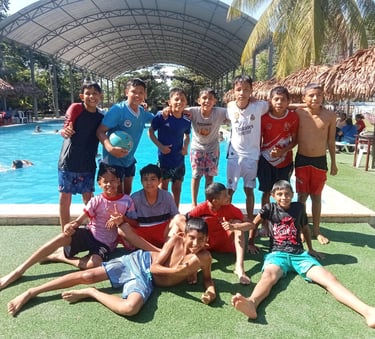 Smiling group of young boys posing together at the pool of Centro Recreacional Mokanranko Pucallpa