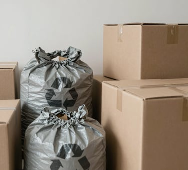 A close-up of a neatly organized collection of cardboard boxes and recycling bags in a clean, empty room in &Icirc;le-de-France, France. The lighting is soft and natural, emphasizing a professional and meticulous sorting process. Minimalist and calm mood with stone gray and beige tones.