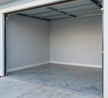 A clean, empty garage space in a North American / US home, highlighting a successful junk removal job. The floor is swept and the area is bright. Accents of light grey and soft sky blue are visible in the background structure.