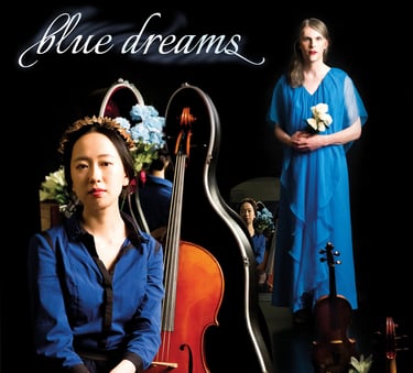 two people in blue with a black backdrop. The person in the front has a cello next two them.  