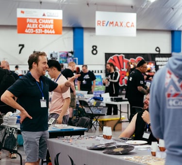 A volunteer smiles and gestures as he excitedly talks with a vendor at the event