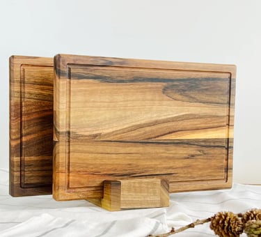a wooden cutting board with a pine cone on top