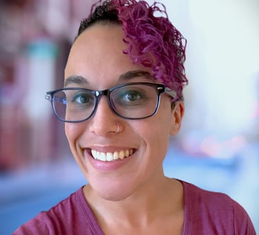 a woman with glasses and a purple shirt