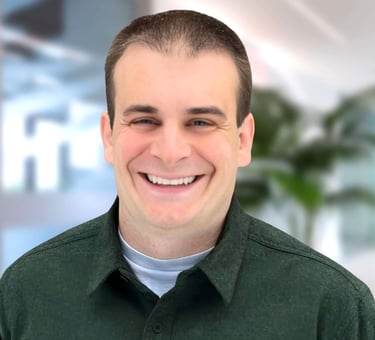 a man in a green shirt smiling at the camera