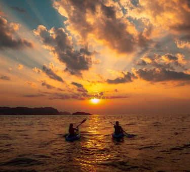 Sugar mommy and sugar baby are kayaking in the ocean at sunset