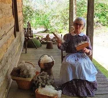 Huntsville, AL - Living history: a lady combs wool to detangle it before spinning