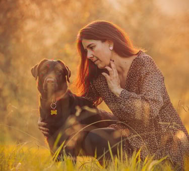 donna con cane su sfondo tramonto arancione