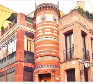 Fachada de ladrillo única de un edificio histórico en Madrid que presenta una torre redondeada con d
