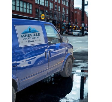 Blue work van with Asheville Locksmith logo driving through West Asheville