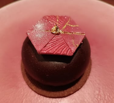Dessert al cioccolato con decorazione geometrica rosa e foglia d'oro servito al ristorante Nobuya Milano