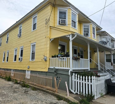 a yellow house with a white picket fence and a white picket fence