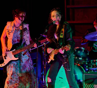Actress Sofia Skates, Sophia Chapdelaine and Tristan Miura play music in a scene of Lupe Q Corn Cake