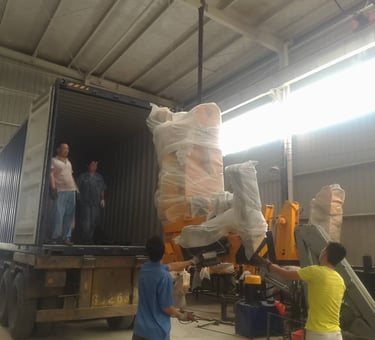 The workers are loading the truck mounted crane into the container