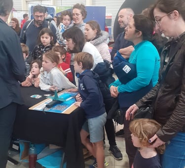 alain surirna is standing in front of a table with child explaining sharks