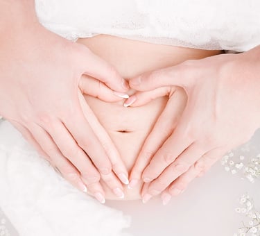 Photo grossesse bain de lait avec les mains en coeur sur le ventre