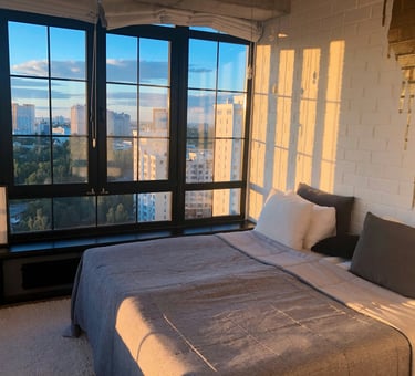 hotel bedroom with a bed and a large window. Digital Nomad Accommodation with Timea Pokol Consultant