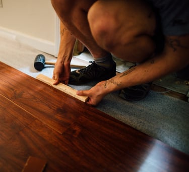 a man is using a tape measure ruler to measure a hardwood floor