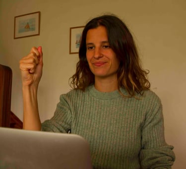 Laura Capit sitting at a table with a laptop computer