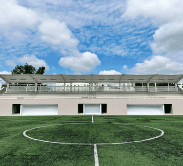  Gradas techadas frente a cancha deportiva sintética | KARÄNA