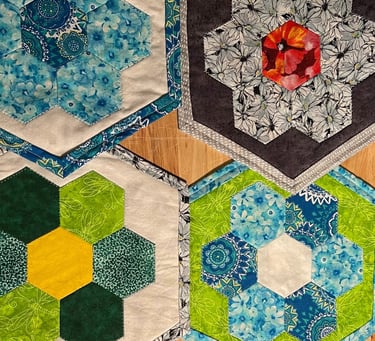 a table with several quilted hexagons