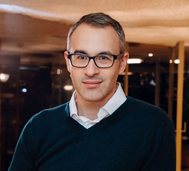 a man in a black sweater and glasses