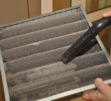 AC technician cleaning and replacing air filter in UAE home