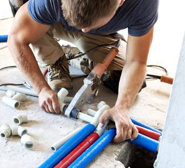 Professional plumber installing new PVC plumbing pipes in UAE building