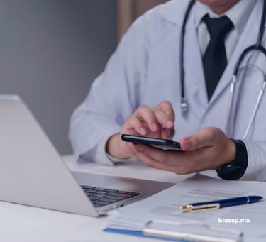 Médico usando laptop y smartphone para gestión clínica digital