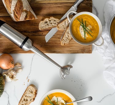 Food product photography - a table with bread and soup and a blender