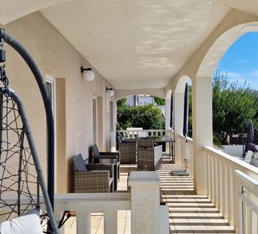 The photo shows the balcony of the apartment with a dining set. 