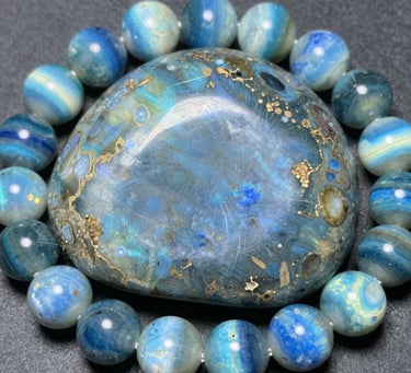 Polished white moonstone bracelet beads and tumbled stones on a dark background.