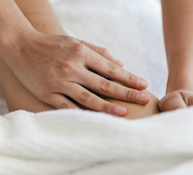 mains effectuant un massage du dos pour soulager les douleur à genève